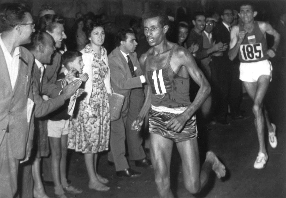 Abebe Bikila running barefoot ahead of Rhadi Ben Abdesselam at the Rome 1960 Olympic marathon