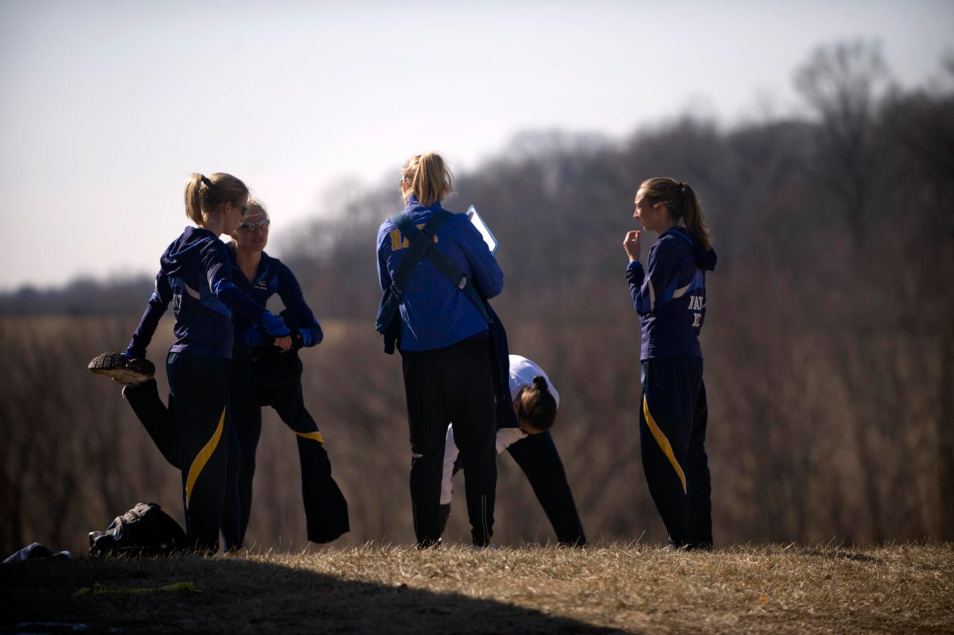 Cross-country runners warming up in long tights before a winter championship race