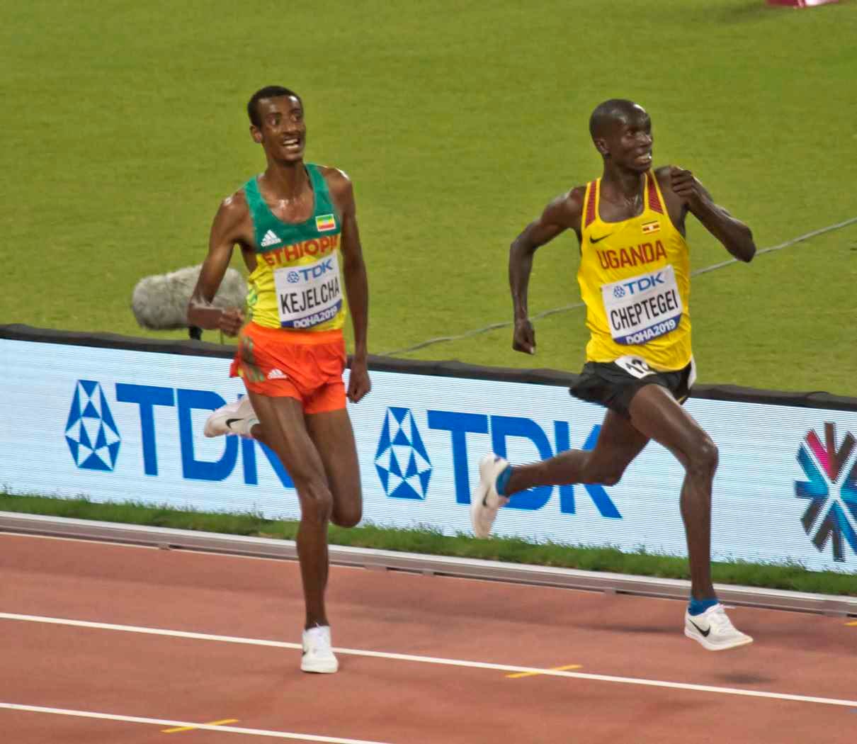 Joshua Cheptegei leading Yomif Kejelcha in the Doha 2019 10,000 m final