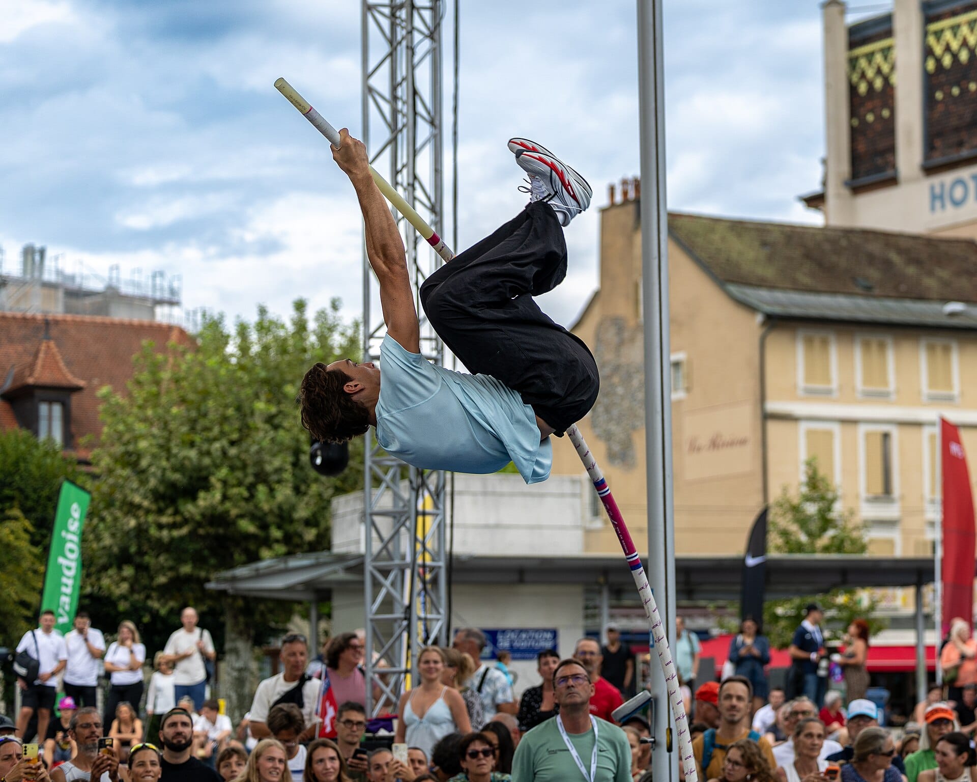 Armand Duplantis vaulting in black track pants during a warm-up at a city pole vault event