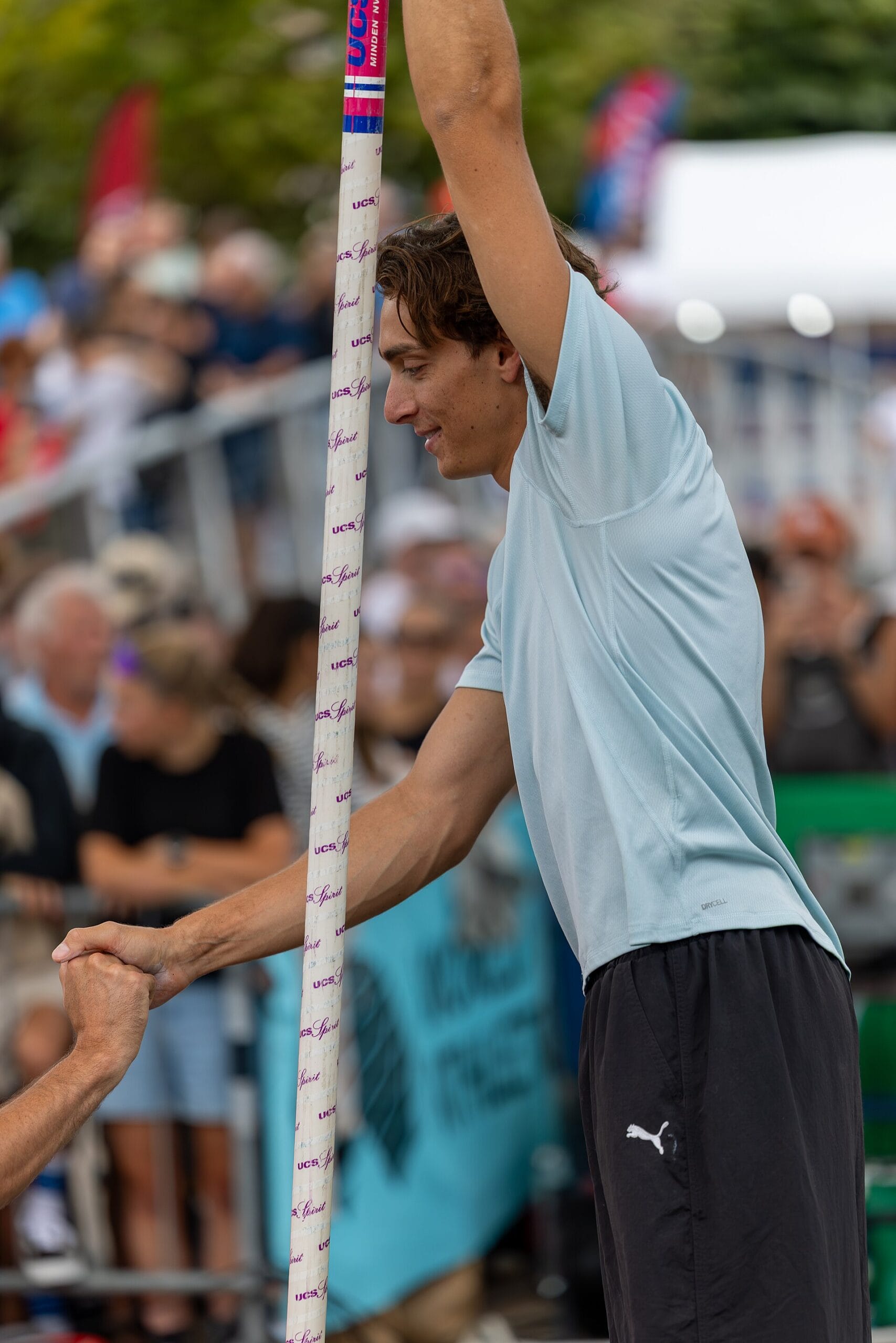 Armand Duplantis warming up in a technical training t-shirt before a city pole vault event