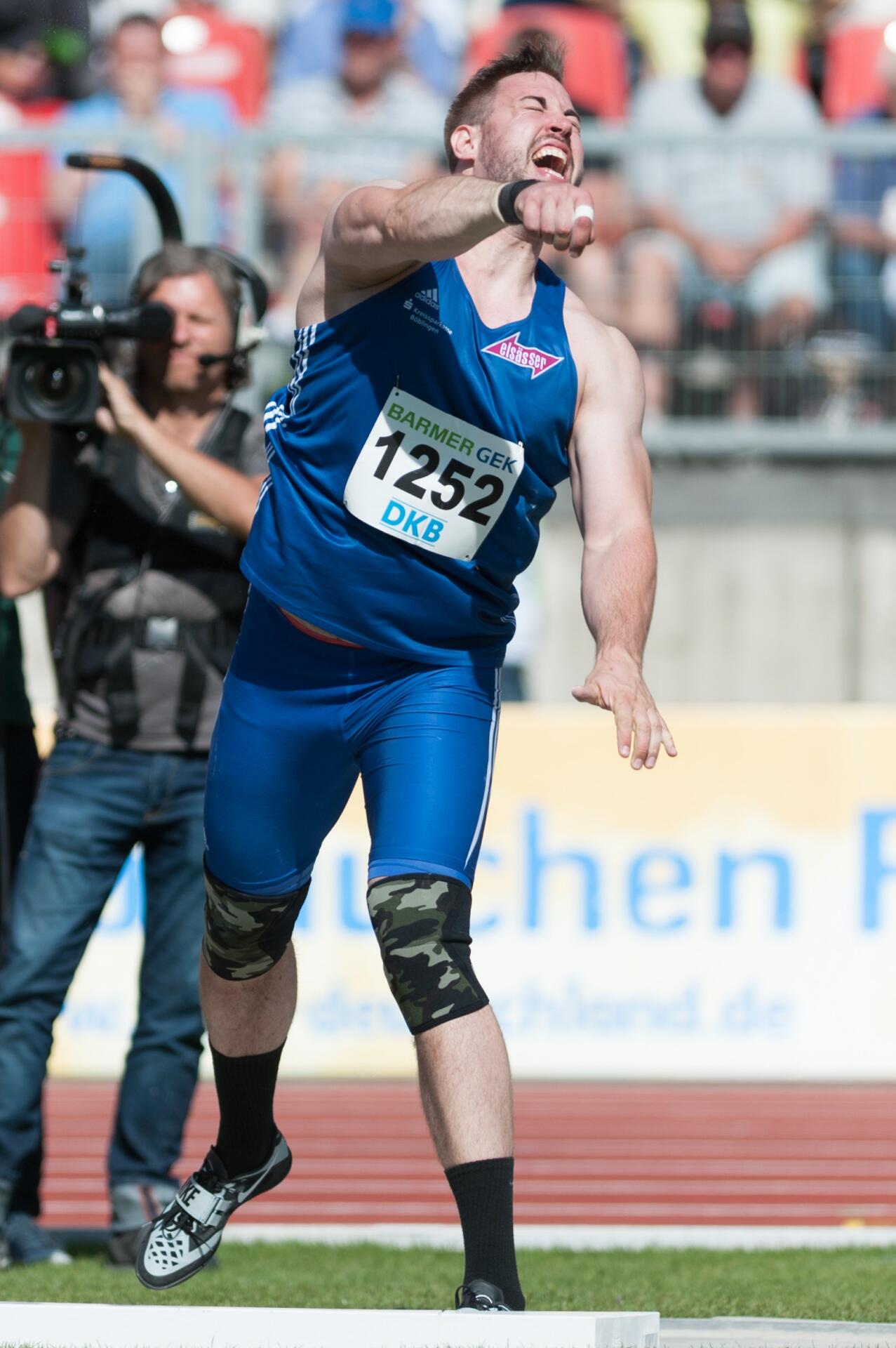 Shot putter at the moment of release, the smooth sole of his rotational throwing shoe visible