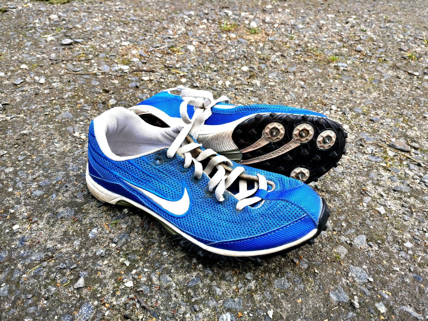 Close-up of modern Nike sprint track spikes showing the forefoot pin plate